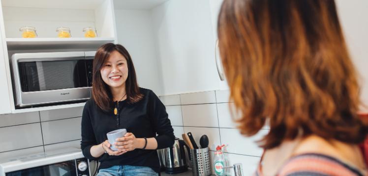 Two students talking in kitchen in accommodation