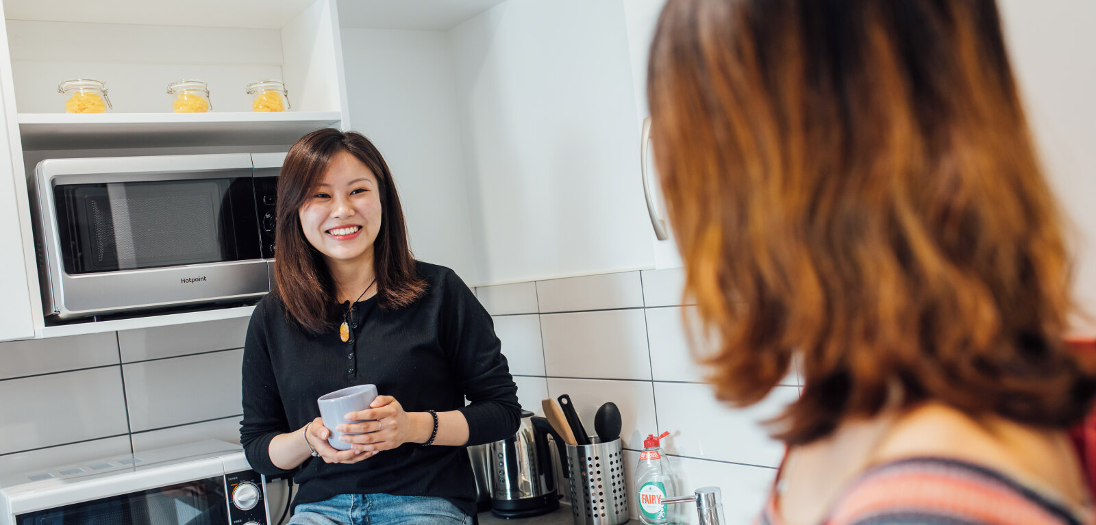 Two students talking in kitchen in accommodation