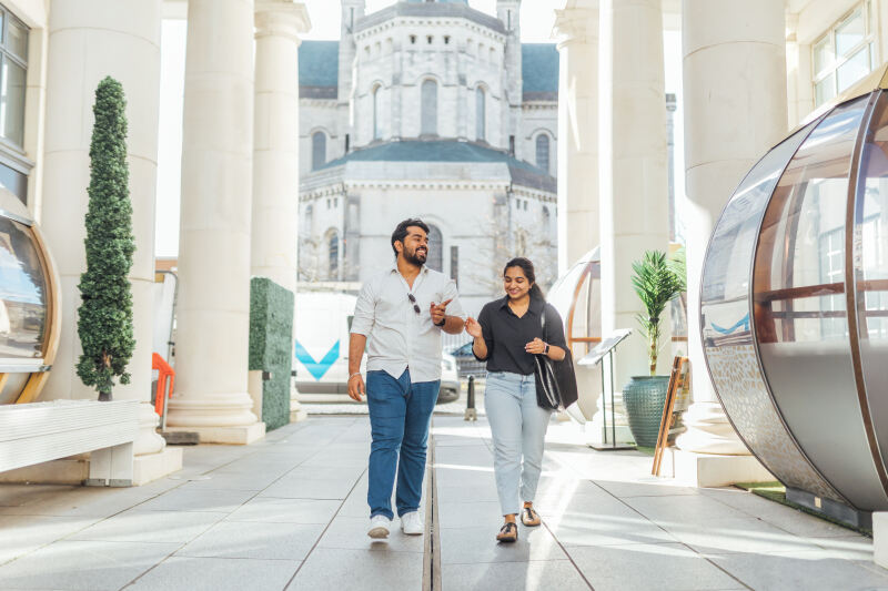 Male and female student walk through St Anne's Square