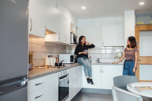 Two students talking in accommodation kitchen