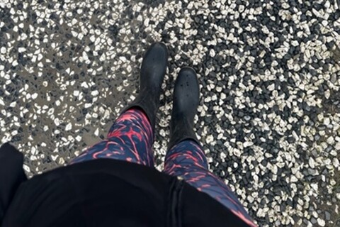 Person in welly boots standing on stones