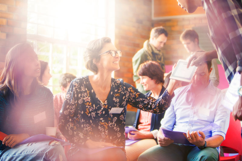 A mixed group of people actively learning and sharing resources