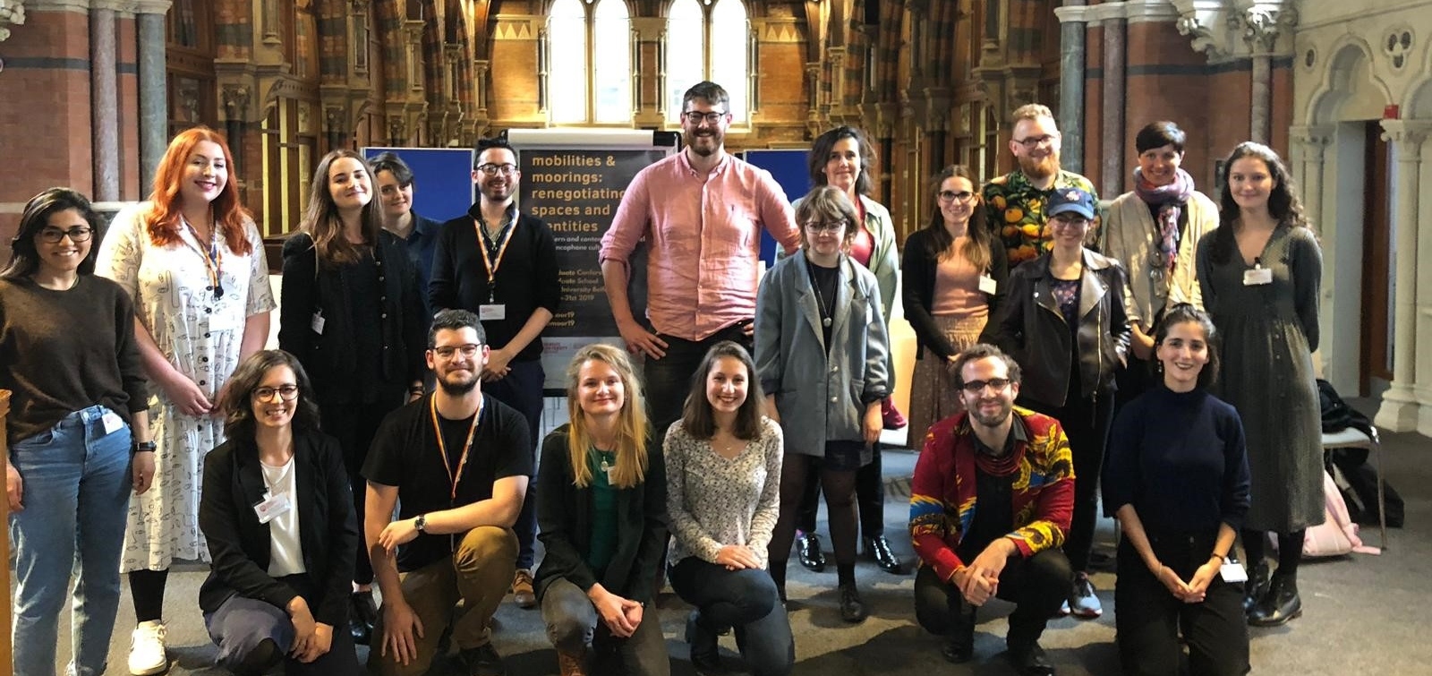 Staff, post-doctoral and post-graduate students in Modern Languages gathered together on the mezzanine area of the Graduate School with those at the back standing and those to the front kneeling.