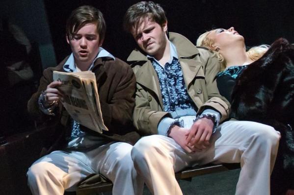 scene of two men on a bench reading a newspaper with a woman in a state of collapse leaning backwards