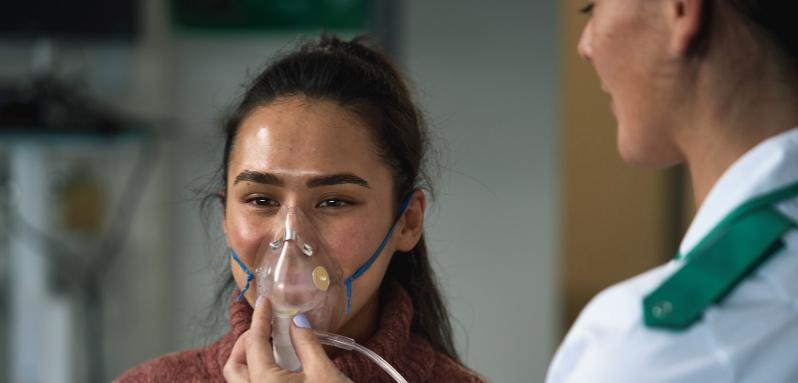 Nursing student putting a mask on a patient