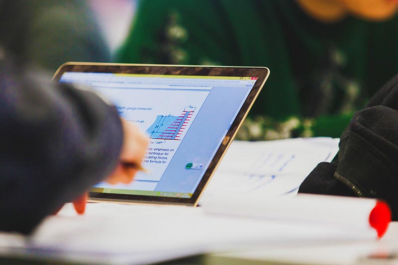 close up of student working on a tablet computer