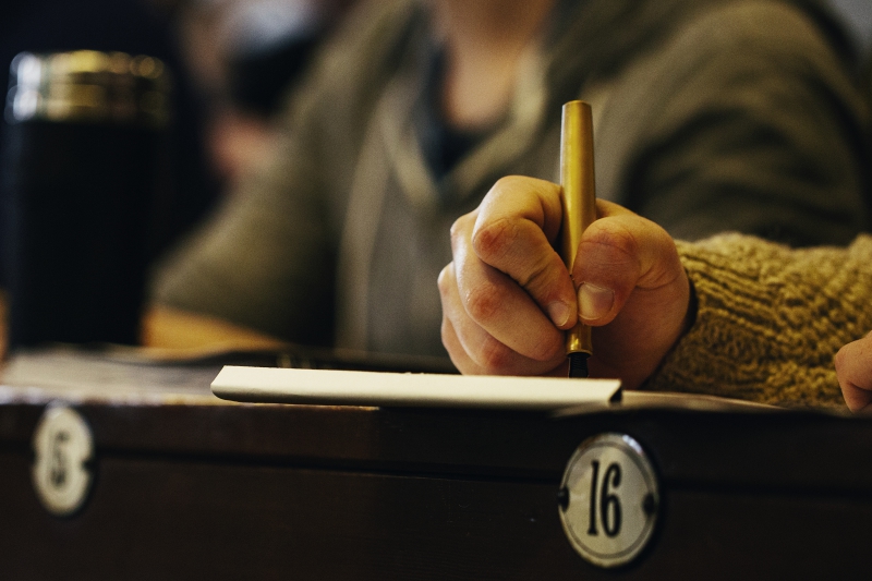 close up of student's hand holding a pen and taking notes