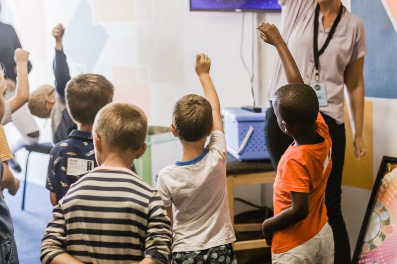 School children raising their hands