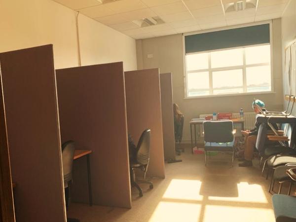 Picture of the CIIR room showing three computer cubicles, a window, and a person with green hair