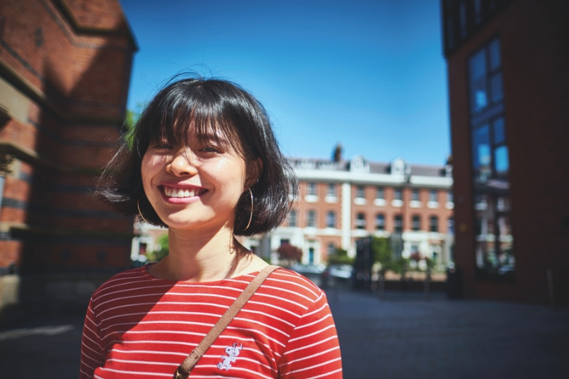 A female student in red top smiling at camera