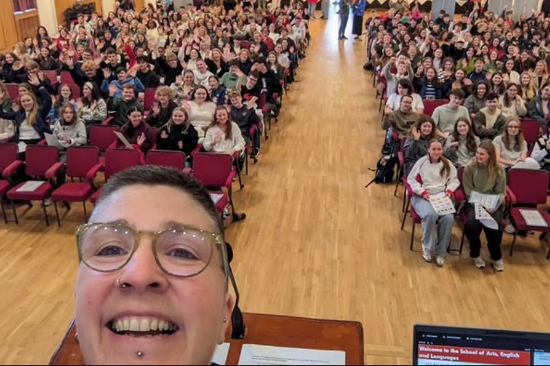 Person talking a photo with students in background