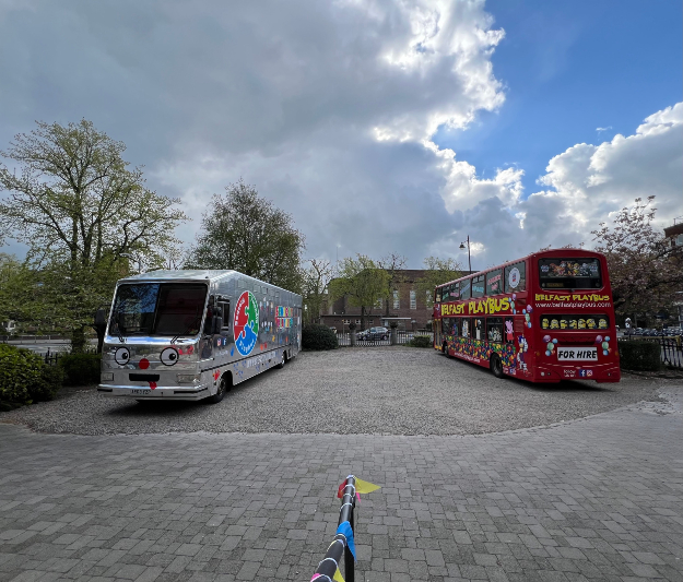 Two painted busses parked beside each other.