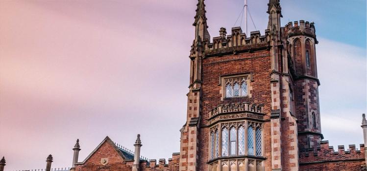 traditional red brickk university building against a pink sky