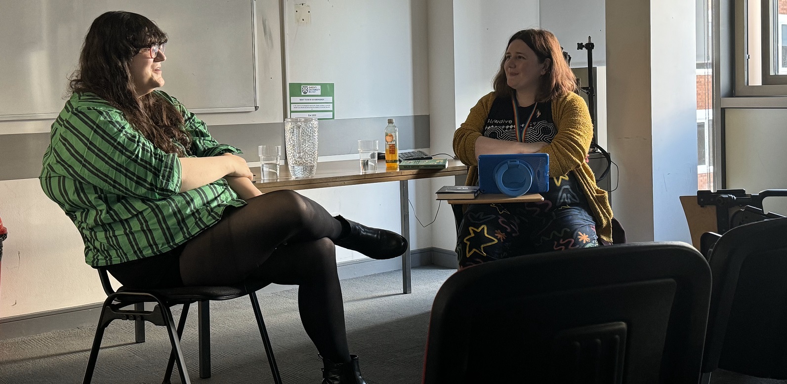 Soula Emmanuel and Emer McHugh seated facing each other in front of a table