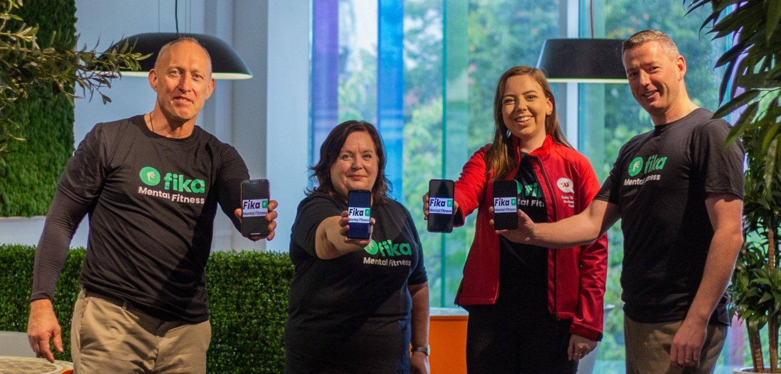 Professor Chris Johnson, Katie Ní Chléire, Denise Clements and Rory Bonnar holding mobile phones showing Fika app