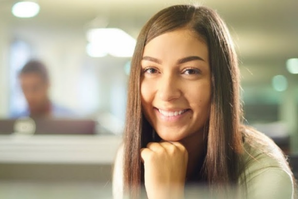 young woman sitting at a desk smiling