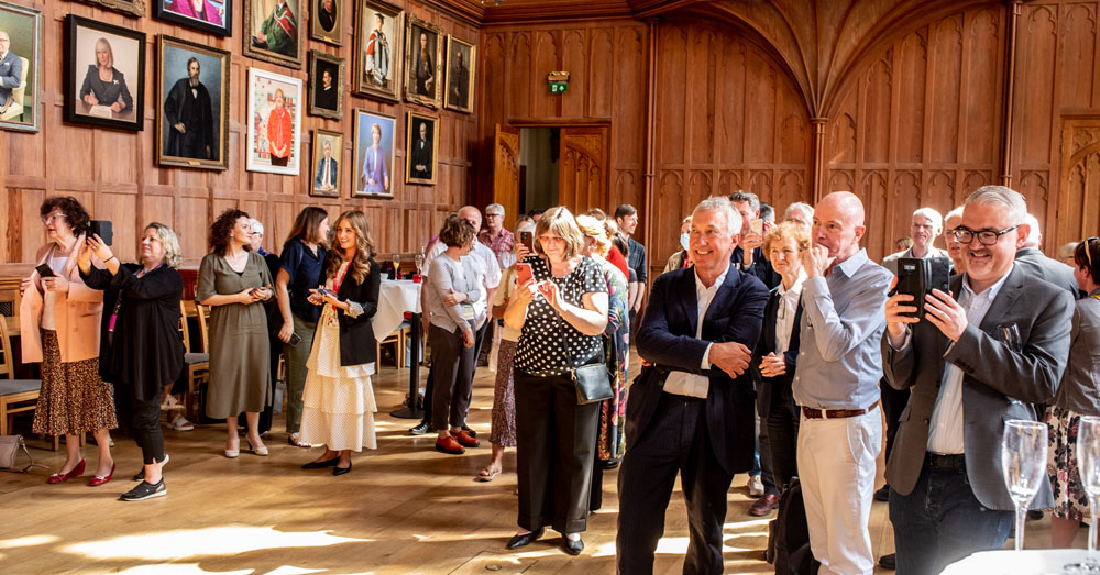 group of guests admiring the Carol McGuinness portrait in Queens Great Hall