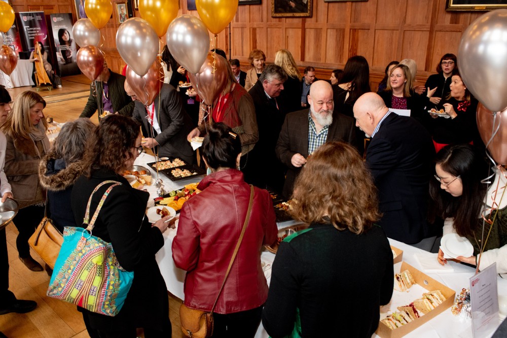 group of people chatting over a celebratory buffet lunch in Queen's University Belfast Great Hall