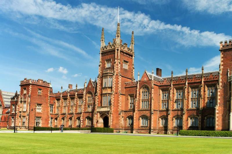 Lanyon Building, Queens University Belfast, with blue sky above and green grass in the foreground