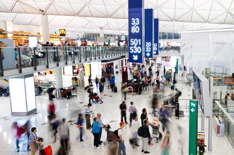 people milling around in an airport or travel hub concourse