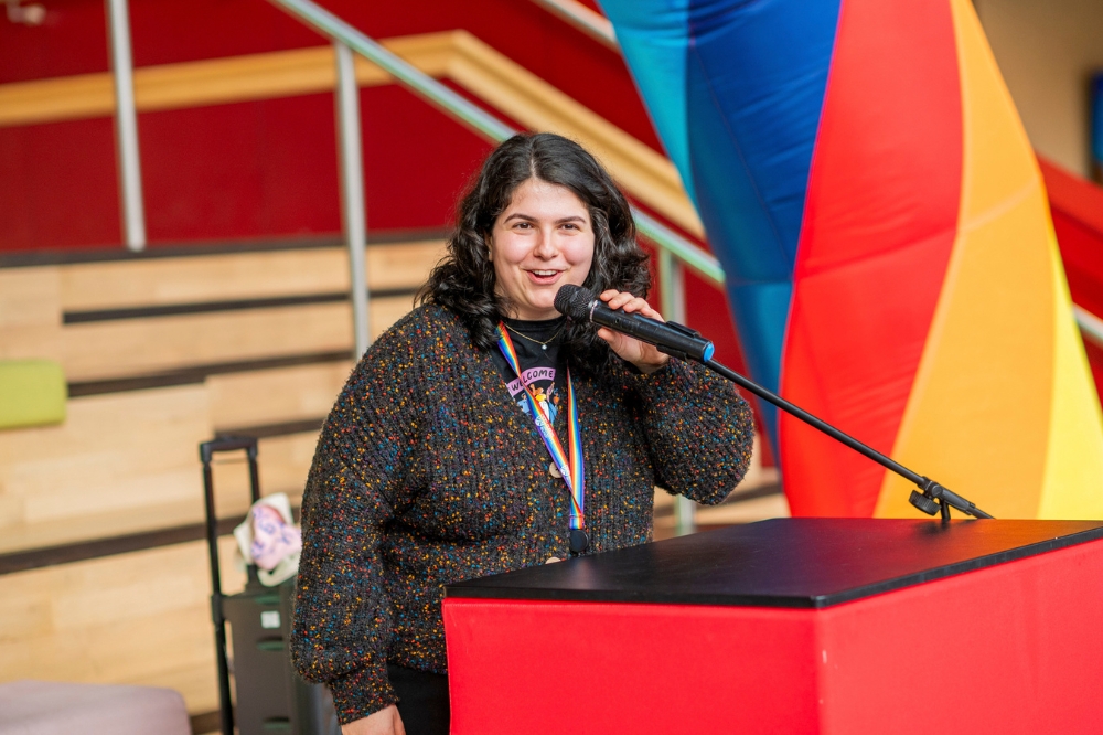 young woman speaking at podium at LGBTQueen's Celebration Showcase