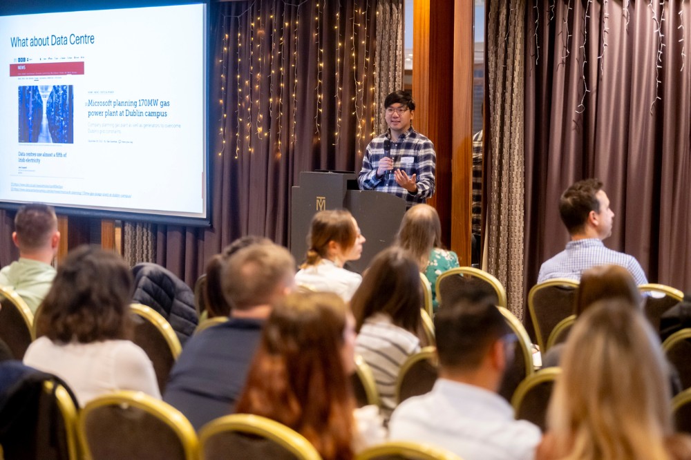 postdoc presenting a flash-talk to a room full of postdoctoral researchers, Malone Hotel, September 2024