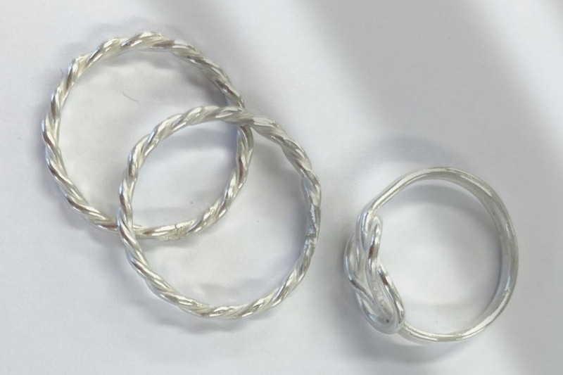 close-up of three handmade silver rings on a display cloth