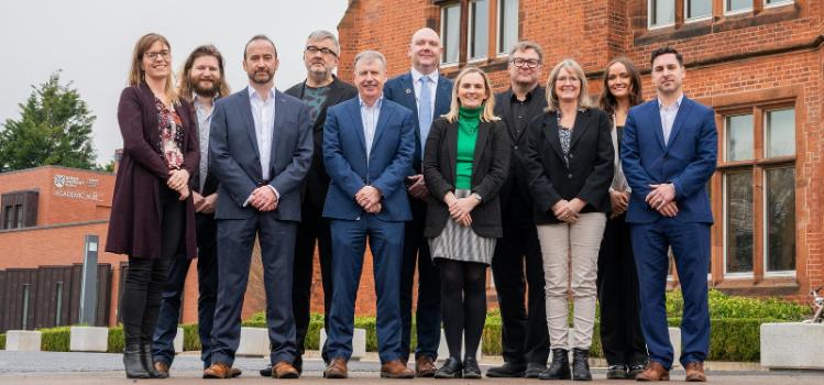 group of conference organisers / speakers / attendees and Queens staff members standing outside Riddel Hall at the first sustainability conference held at the University