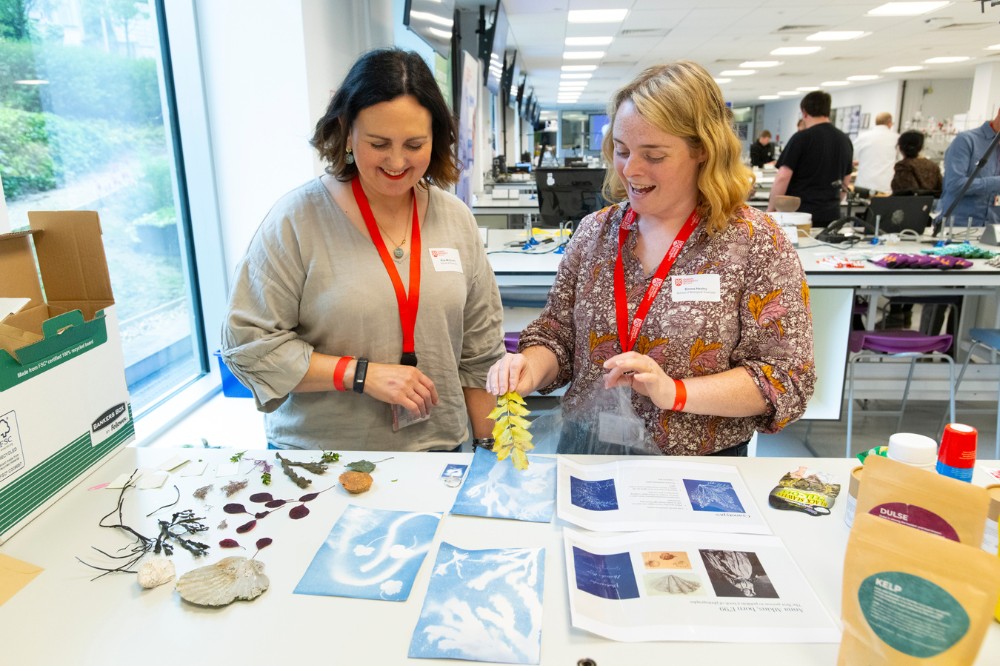 two female technicians chatting over a table display at the Technician Showcase 2024